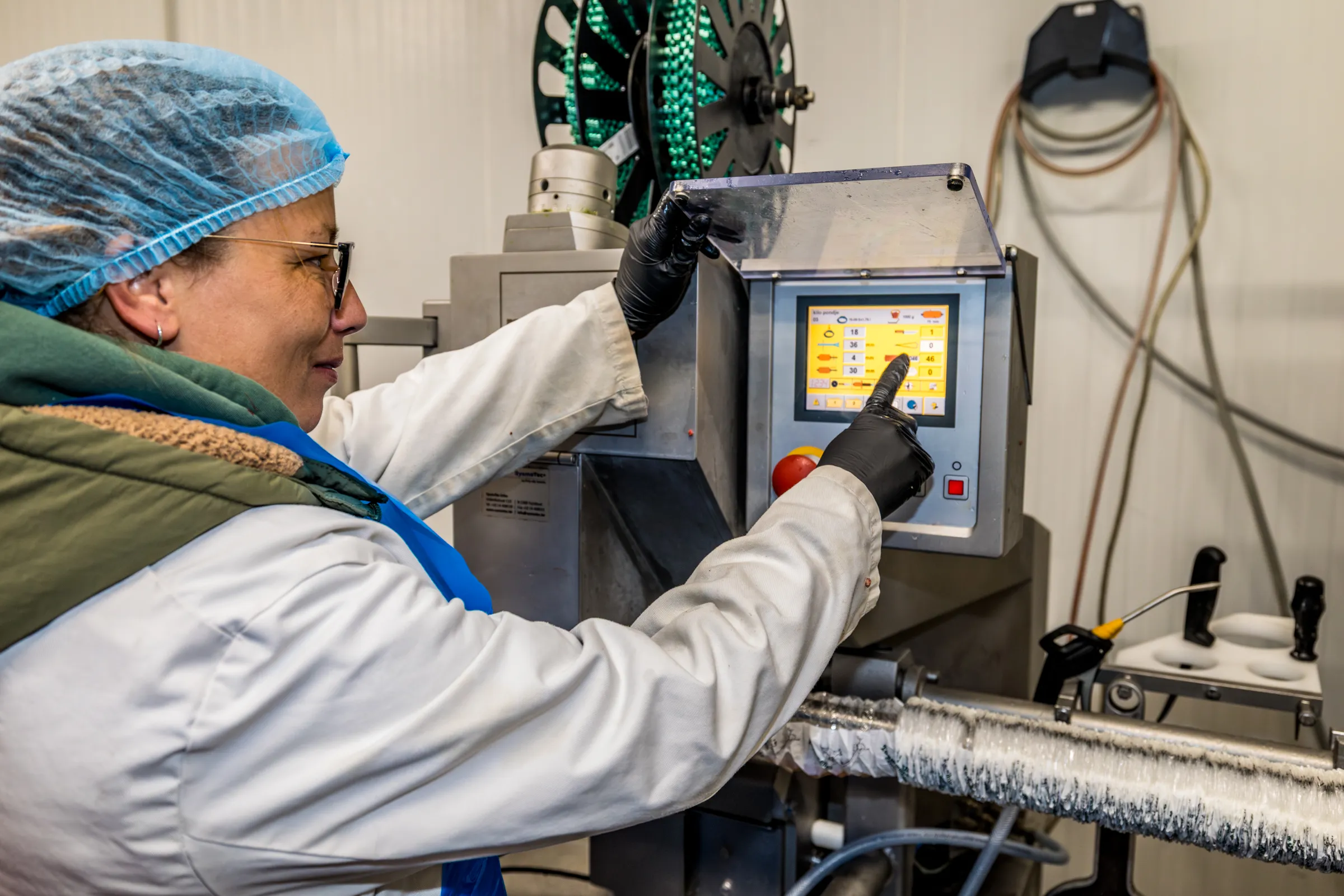 Medewerker bedient de worstmachine